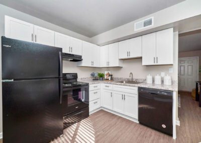 A well-designed kitchen with pristine white cabinets and chic black appliances, offering a striking contrast and modern appeal.