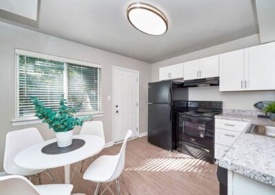 A bright kitchen showcasing elegant white cabinetry alongside sophisticated black appliances, enhancing the overall design.